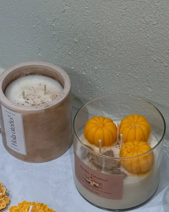 Vela ¡Hola otoño! en vaso mate junto a la vela de calabazas